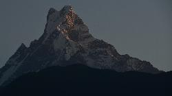 The Fishtail mountain rises steeply above the hills surrounding it.