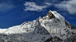 The snowstorm stops and just before sunset the clouds open up for a fine view of the steep west face of Fishtail (6'993 m).