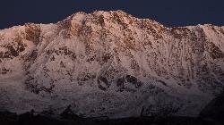 The few moments before sunrise turn the mountains into a magic light, the orange sun will wander down the steep 3'500m vertical wall in an instant.