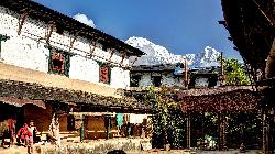 Gurung house in Gandrk with Hiunchuli and Annapurna South rising into the blue sky.