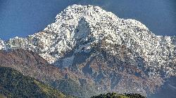 Rising high above the ridge near Komrong, the hanging glaciers of Annapurna South cling to its steep south face.