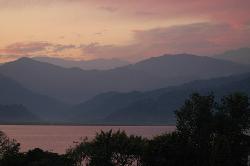 Sunset turns the clouds and the lake in a pink light.