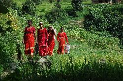 Women in traditional red dresses on the way to Sankhu.