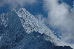 Fog is blowing up from Lukla; and increases the grandeur of the mountain flanks.