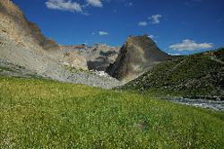 Wide barley fields contrast with the barren rockfaces.