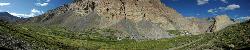 Panorama of the stunning valley with its bright green fields at the foot of the hills.