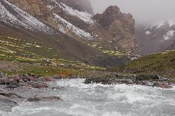 The river has swollen the last two days; and gushes past our campsite towards the village.