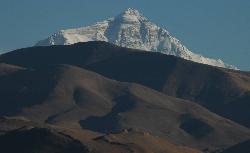 Everest rising over the barren hills of the Tibetan plateau.