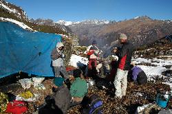 After a strange night with little rest - porters wake me with fearful faces because they have heard yetis laughing on the ridge just above us, and made me move my tent to the fire - porters eat breakfast and prepare for a tough day.