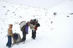 After struggling over boulders we're in deep snow and more comes falling from low clouds.